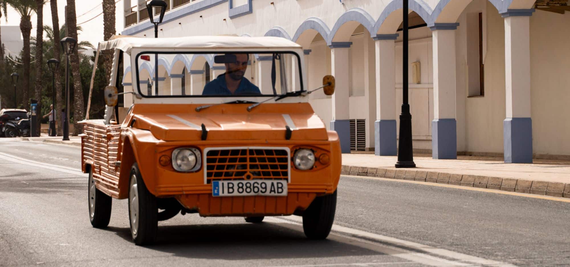 Driving through Ibiza in a small island car during a scenic road trip.